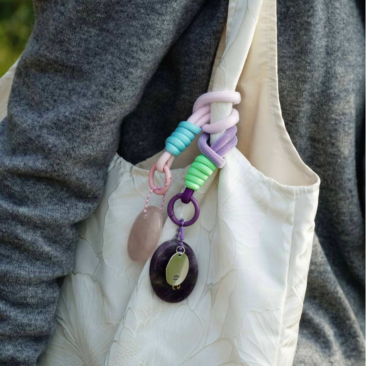Lavender affirmation crystal charm clipped to white canvas bag