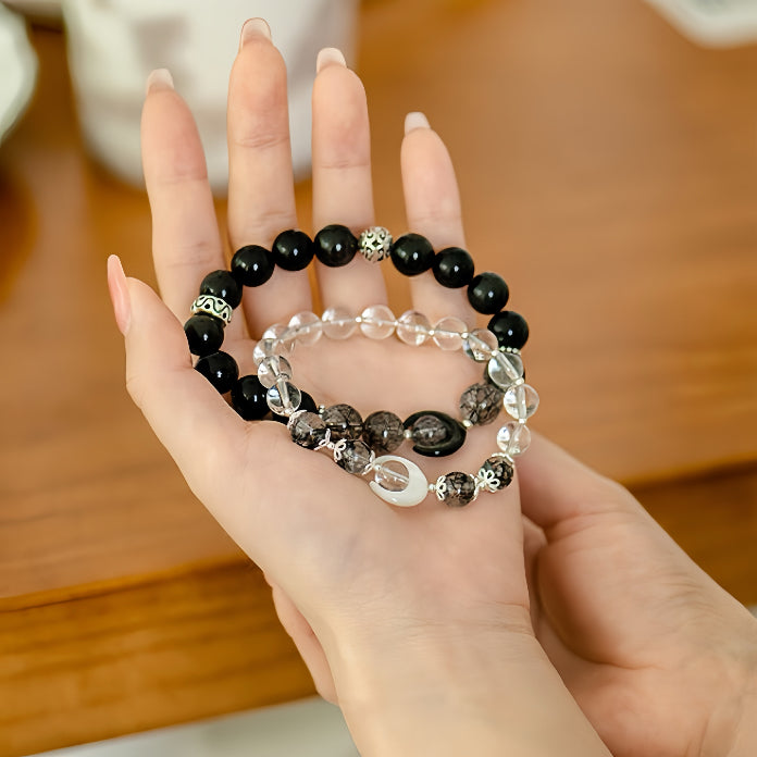 Hand holding black and white crystal bracelets