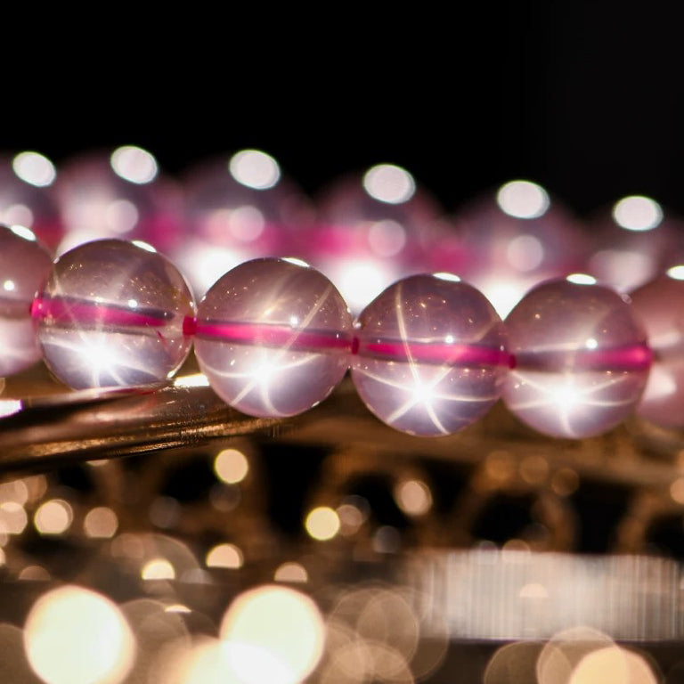 Close-up of sparkling Rose Quartz beads under soft lighting