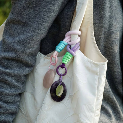 Lavender affirmation crystal charm clipped to white canvas bag
