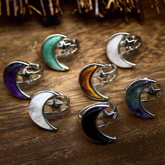 Moon & Star crystal rings styled on a wood background