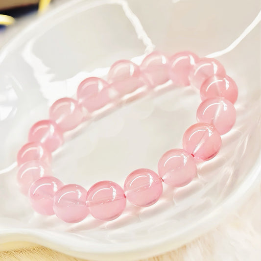 Rose Quartz Bracelet in a white ceramic bowl, showing soft pink glow