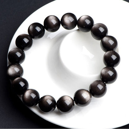 Obsidian bracelet displayed on white plate
