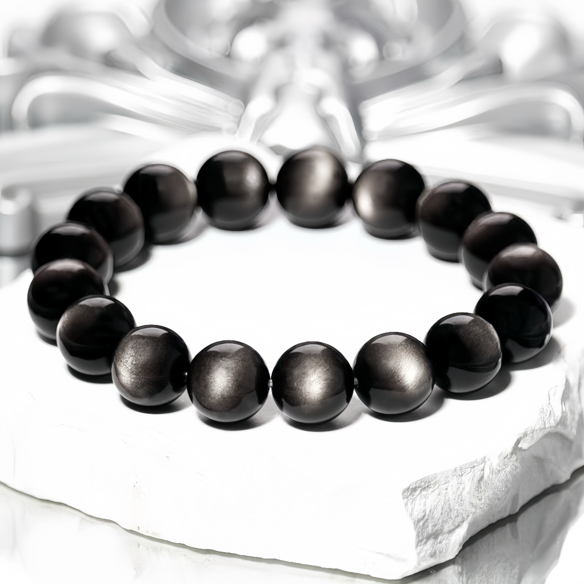 Glossy Silver Sheen Obsidian beads on textured background
