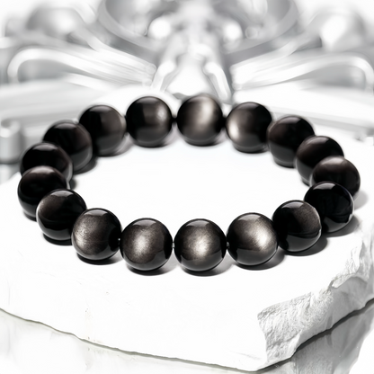 Glossy Silver Sheen Obsidian beads on textured background
