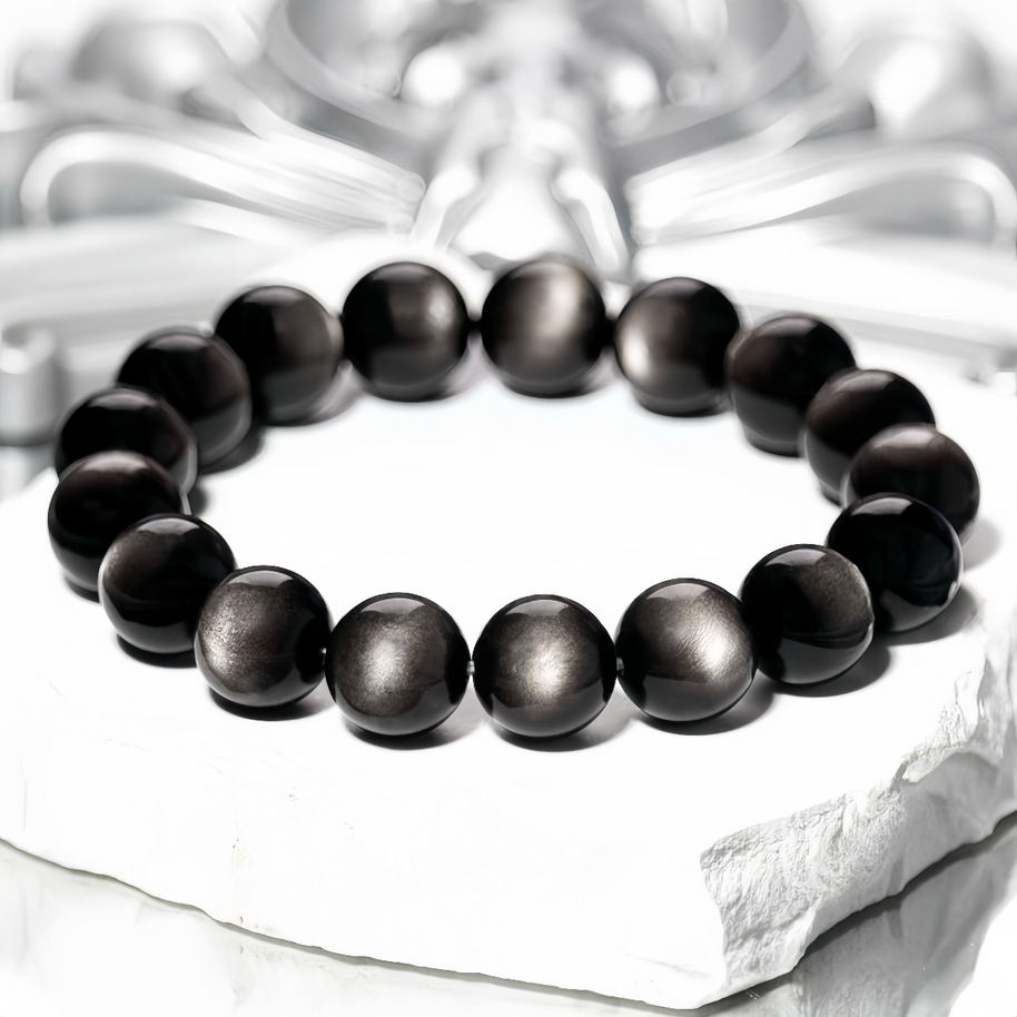 Glossy Silver Sheen Obsidian beads on textured background
