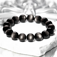 Glossy Silver Sheen Obsidian beads on textured background
