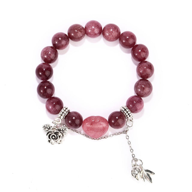 Front view of strawberry quartz bracelet with heart centerpiece and silver charms