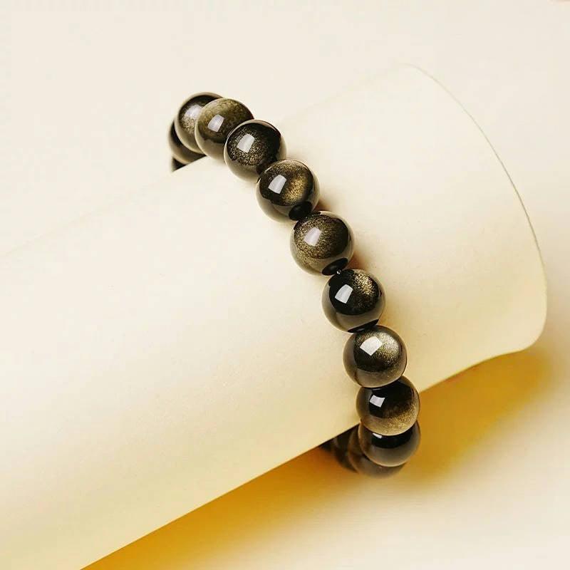 Golden Obsidian bracelet wrapped around soft yellow prop